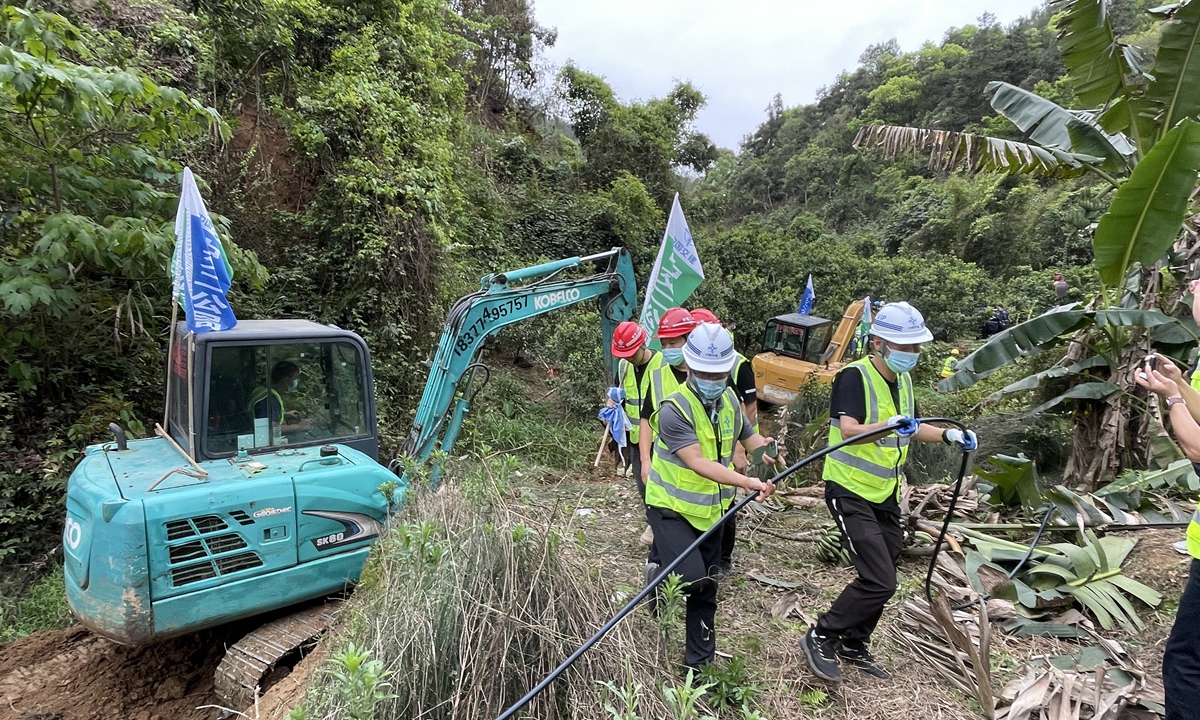 An excavator helps to clean the bushes and barriers for following search work at the crash site on March 22, 2022. Photo: Xinhua