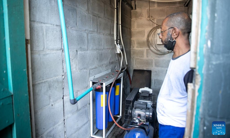 A worker showcases a filter of water tanks at a car wash station in Cape Town, South Africa, on March 19, 2022.(Photo: Xinhua)