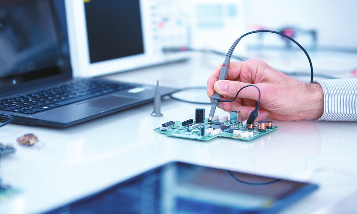 A researcher studies a microprocessor in a lab. Photo: VCG