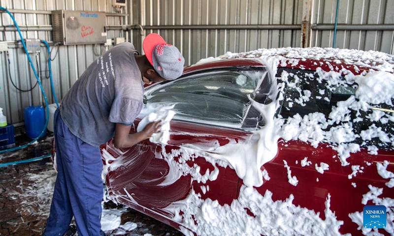 A worker washes a car at a car wash station in Cape Town, South Africa, on March 19, 2022.(Photo: Xinhua)