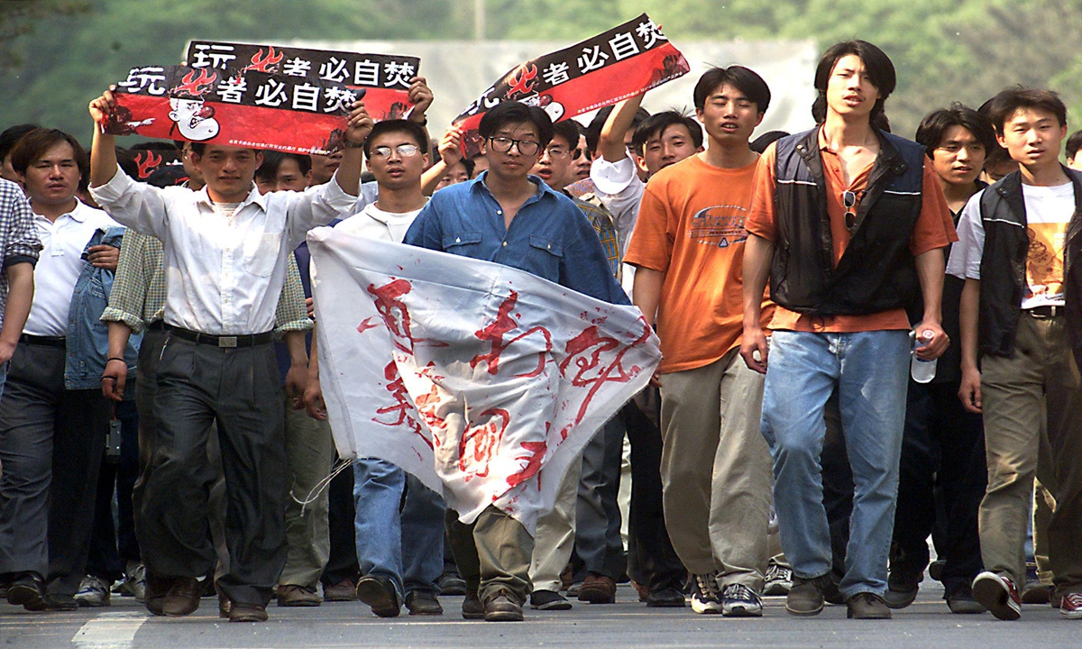 A group of angry students and workers march toward the US embassy in Beijing on May 11, 1999 to protest the killing of three Chinese journalists following NATO's bombing of the Chinese Embassy in Belgrade, capital of now defunct Republic of Yugoslavia. China repeatedly reminds NATO that it owes blood debt to Chinese people.STEPHEN SHAVER / AFP