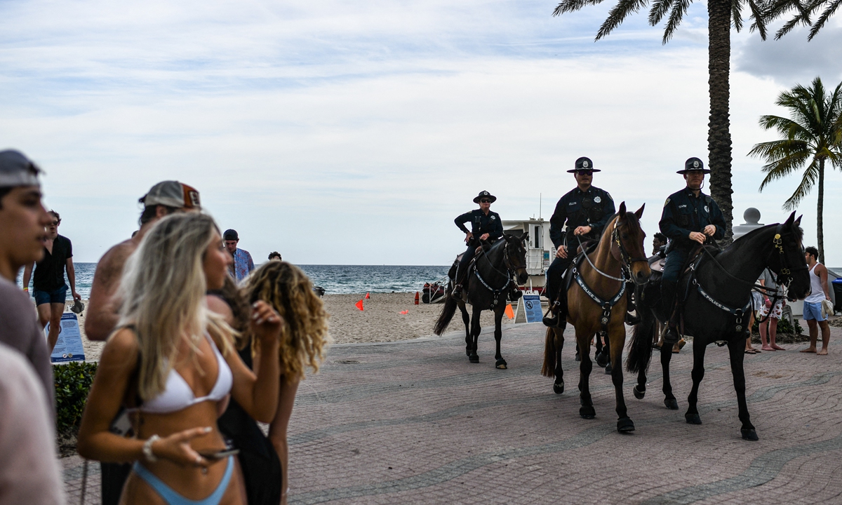 Mounted police officers escort revelers off the beach on Las Olas Boulevard in Fort Lauderdale, Florida, on March 16, 2022. Photo: AFP