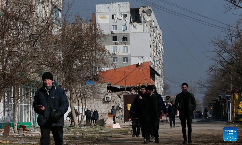 People pass by damaged buildings in Mariupol, Ukraine, March 23, 2022.(Photo: Xinhua)