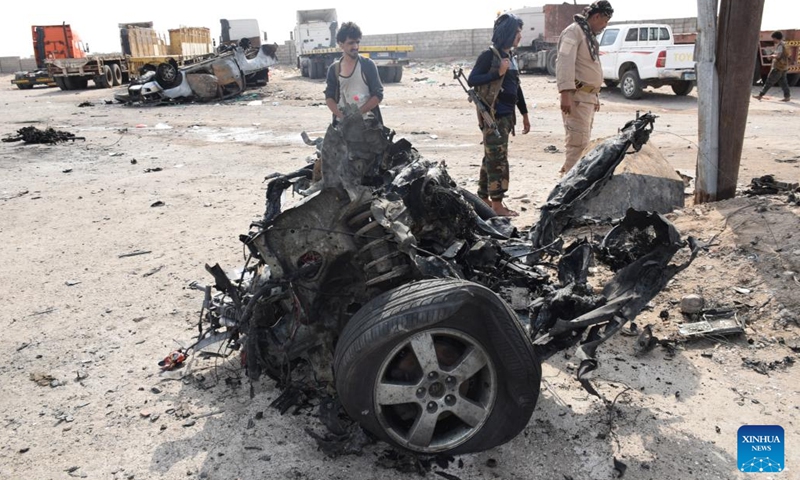 Security officers stand next to the wreckage of a car on a street of Aden, the southern port city of Yemen, on March 24, 2022.(Photo: Xinhua)