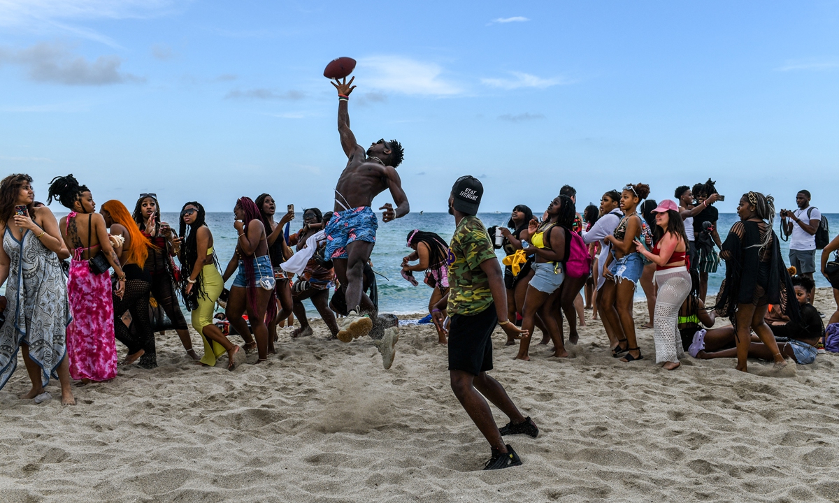 Revelers play beach football on the sand in Miami Beach, Florida, on March 17, 2022. Photo: AFP