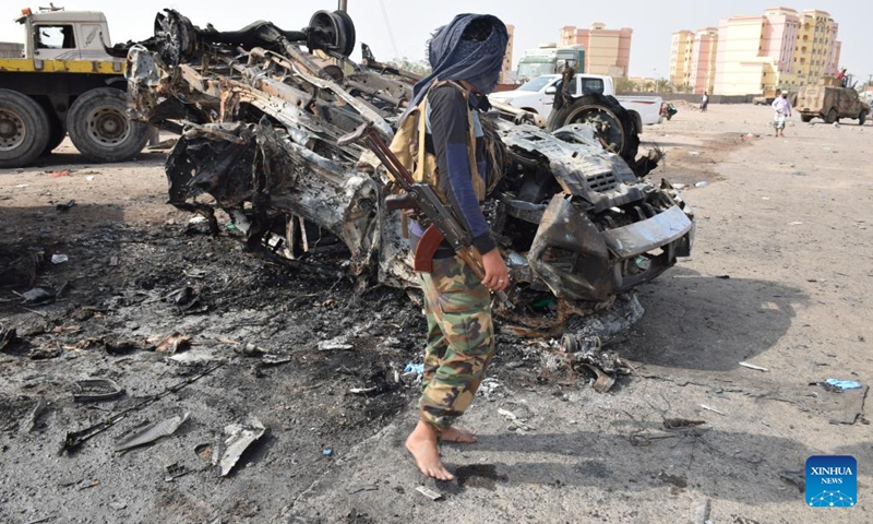 A security officer stands next to the wreckage of a car on a street of Aden, the southern port city of Yemen, on March 24, 2022.(Photo: Xinhua)