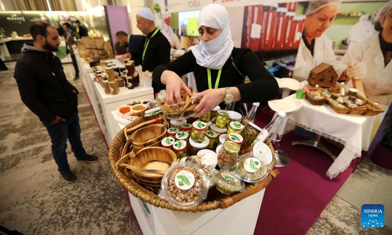 An exhibitor arranges products at HORECA trade show in Beirut, Lebanon, on March 24, 2022.  (Photo: Xinhua)