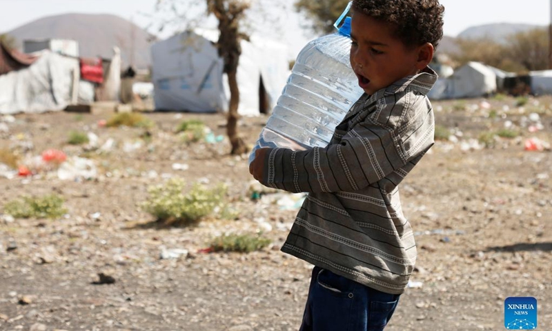 A child carries a bottle of water at the Dharawan camp for internally displaced persons (IDPs) near Sanaa, Yemen, on March 25, 2022. Yemen has been mired in a civil war since late 2014 when the Iran-backed Houthi militia seized control of several northern provinces and forced the Saudi-backed Yemeni government of President Abd-Rabbu Mansour Hadi out of the capital Sanaa.(Photo: Xinhua)