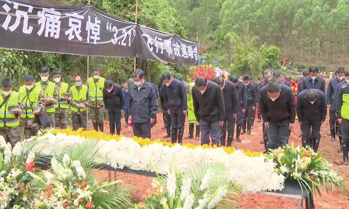 In a screenshot from a video, staff from national emergency response headquarters and rescue workers mourn the 132 victims of flight MU5735, at the site of the crash in Tengxian county, South China's Guangxi Zhuang Autonomous Region on March 27, 2022.Photo:IC