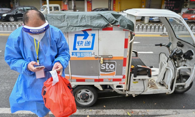 A courier contacts a resident over the phone to fulfil an online order in Quanzhou, southeast China's Fujian Province, March 26, 2022.Photo:Xinhua