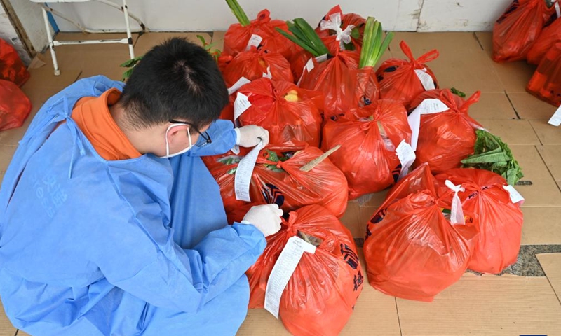 A courier checks residents' order lists at a supermarket's distribution center in Quanzhou, southeast China's Fujian Province, March 26, 2022.Photo:Xinhua