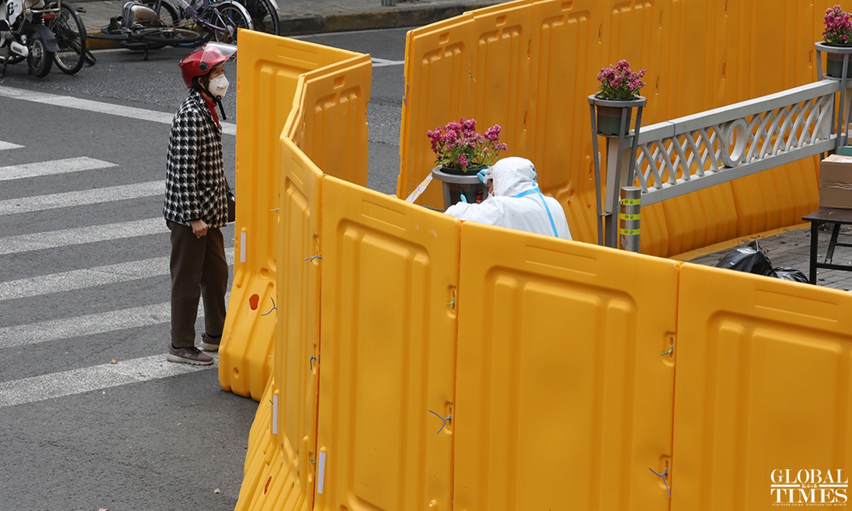 On Kangding road, Jing'an district of Shanghai, street barriers are placed to manage traffic outside the neighborhood communities. Some residents were jogging, while sanitation workers were busy collecting garbage.Photo: Hu Gong