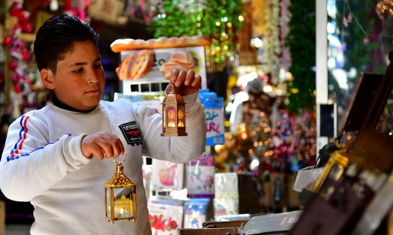 A boy looks at decorations for the upcoming holy month of Ramadan in Damascus, Syria, on March 27, 2022.Photo:Xinhua
