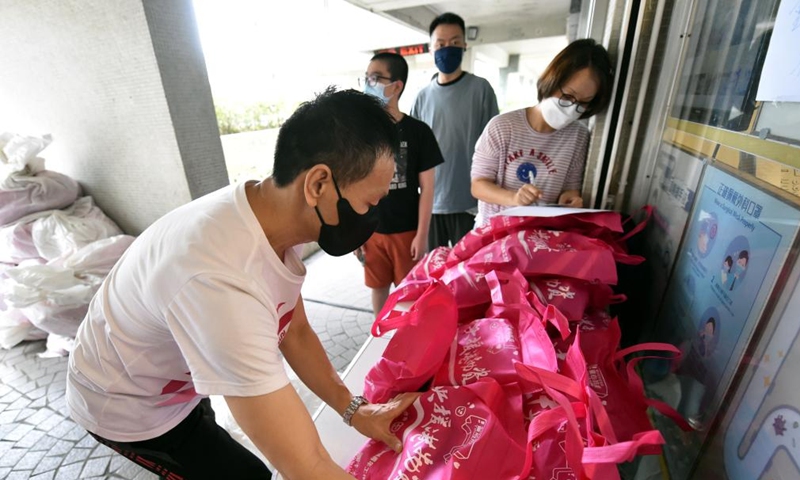 Staff distribute epidemic control supplies to residents in Hong Kong, south China, March 27, 2022.Photo:Xinhua