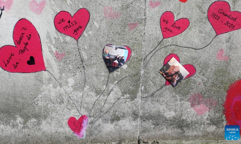 Hand painted hearts and messages commemorating victims of the COVID-19 pandemic are seen on the National COVID Memorial Wall in London, Britain, March 27, 2022.(Photo: Xinhua)