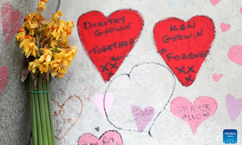 A bunch of flowers are laid as a tribute to victims of the COVID-19 pandemic on the National COVID Memorial Wall in London, Britain, March 27, 2022.(Photo: Xinhua)