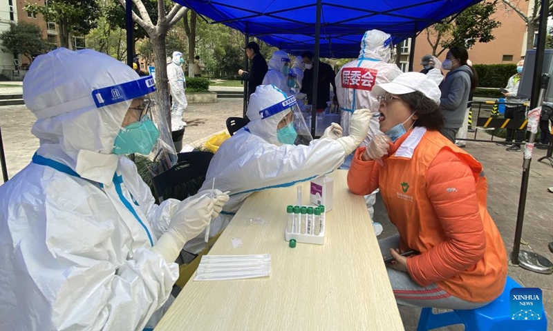 A medical worker takes a swab sample from a resident for nucleic acid test at a COVID-19 testing site in Pudong District, east China's Shanghai, March 28, 2022.Photo:Xinhua