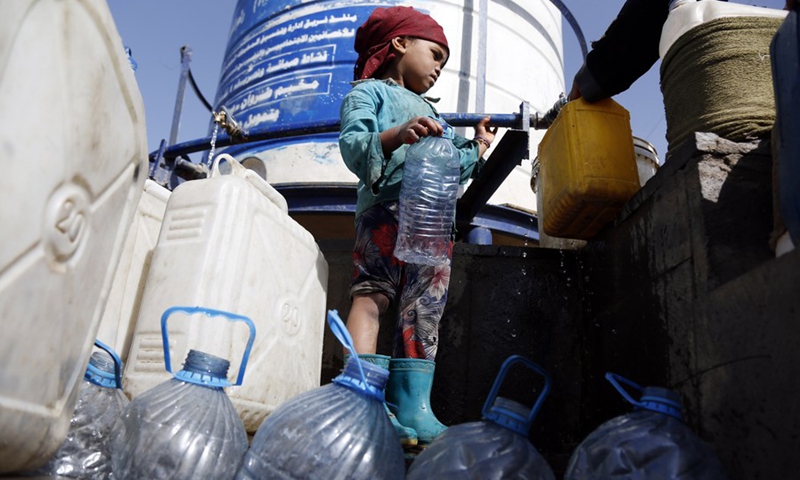 A child carries a large water bottle at the Dharawan camp for internally displaced persons (IDPs) near Sanaa, Yemen's capital, on March 25, 2022.(Photo: Xinhua)
