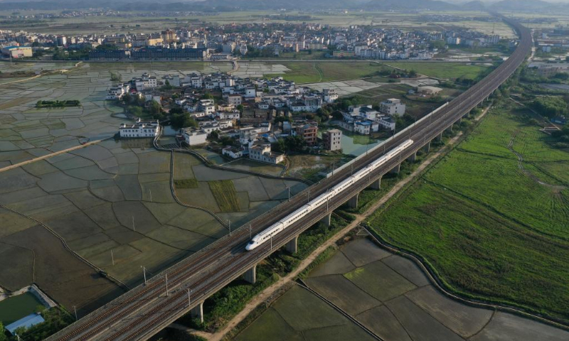 In this aerial photo, a high-speed train runs on the bridge above fields in Binyang County, south China's Guangxi Zhuang Autonomous Region, April 4, 2022. (Xinhua/Huang Xiaobang)