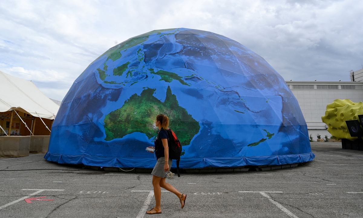 A woman walks past a partial replica of the Earth during the IUCN congress in Marseille, southern France on September 3, 2021, to urge world leaders to protect biodiversity. Photo: AFP