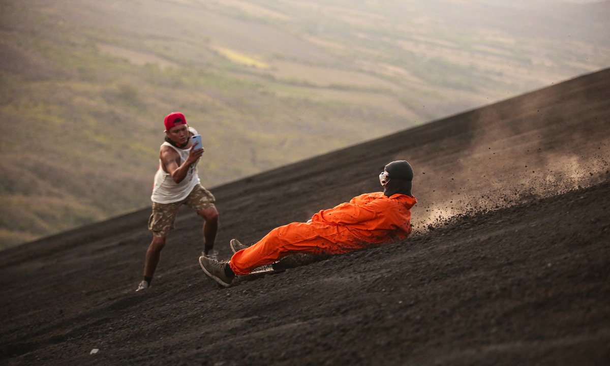 Tourists climb the Cerro Negro volcano, one of the youngest in Central America and one of the most active in the country, in Leon, Nicaragua, on March 22, 2022. Photo: AFP