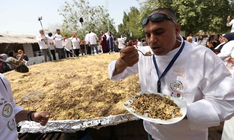 Palestinian chefs cook a four-and-a-half-ton Mujaddara dish in the West Bank city of Jericho on March 30, 2022.(Photo: Xinhua)