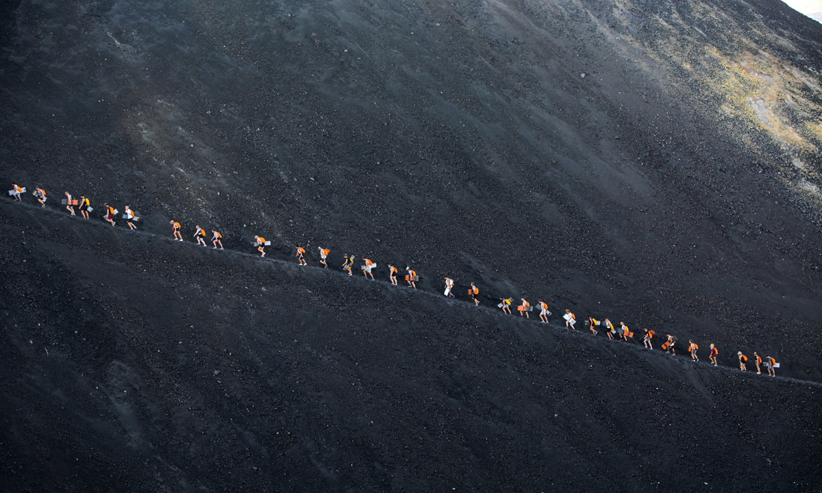 Tourists climb the Cerro Negro volcano, one of the youngest in Central America and one of the most active in the country, in Leon, Nicaragua, on March 22, 2022. Photo: AFP