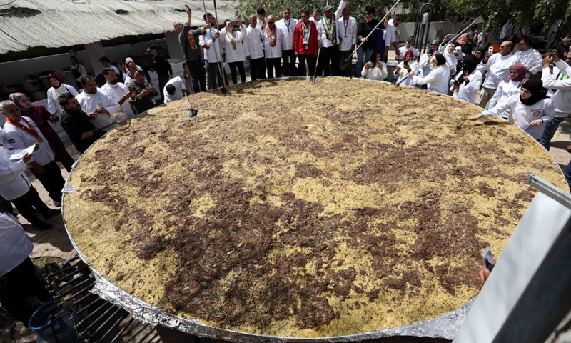 Palestinian chefs cook a four-and-a-half-ton Mujaddara dish in the West Bank city of Jericho on March 30, 2022.(Photo: Xinhua)