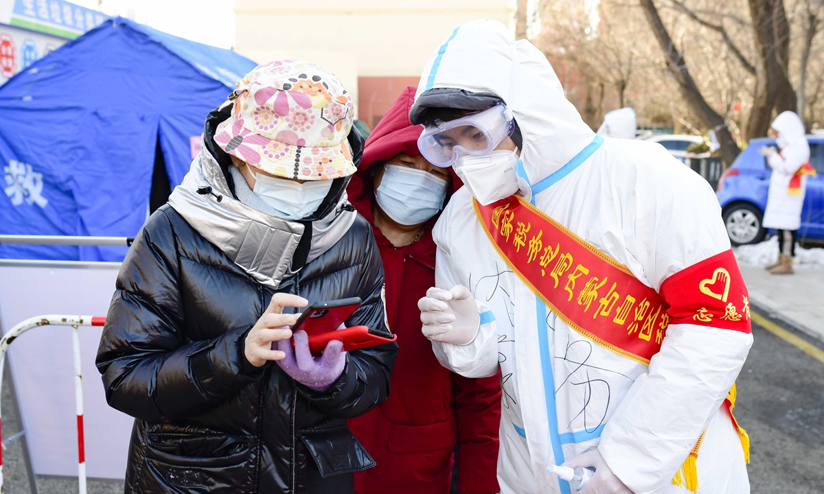A volunteer checks a person's health code in Hohhot, North China's Inner Mongolia Autonomous Region on February 21, 2022. Photo: IC