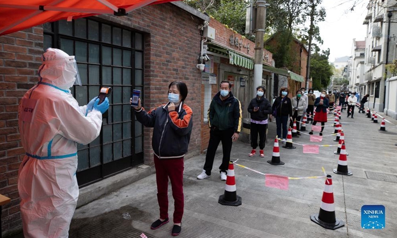 A community worker helps local residents register information before nucleic acid test in Changning District of east China's Shanghai, April 1, 2022. Shanghai has launched a nucleic acid testing campaign in areas west of the Huangpu River from Friday amid the second phase of the city's closed-off management.Photo:Xinhua