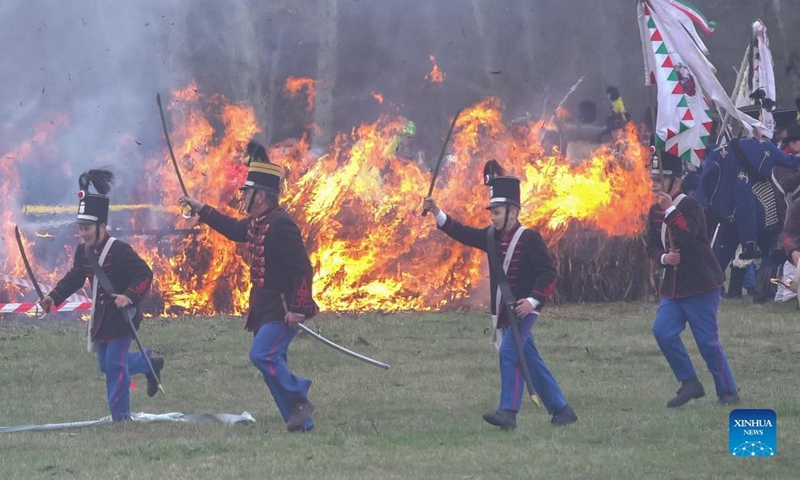 People in period military uniforms re-enact a historic battle in Tapiobicske, Hungary, April 4, 2022. Battle of Tapiobicske was fought on April 4, 1849 between the Hungarian army and the Austrian Empire during the Hungarian War of Independence. (Photo by Attila Volgyi/Xinhua)