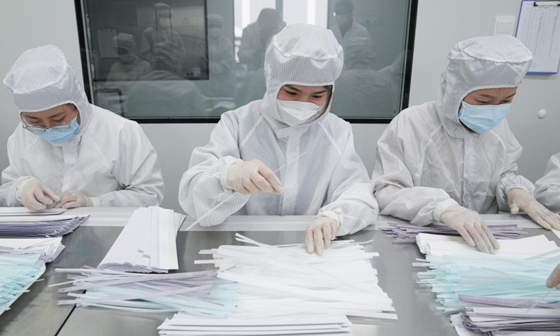 Staff members work at a production line of COVID-19 self-testing kits at Biouhan healthcare company in Hefei, east China's Anhui Province, March 29, 2022.Photo:Xinhua