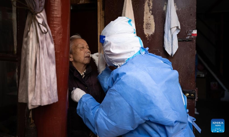 A medical worker conducts antigen testing for an elder resident in Shanghai, east China, April 3, 2022.（Xinhua）