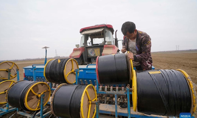 A farmer installs hoses for drip irrigation in a field in Wusu City, northwest China's Xinjiang Uygur Autonomous Region, March 31, 2022. Spring farming has started in northern Xinjiang. In 2022, local authorities will strive to achieve a mechanization level of 85.7 percent for all crops in Xinjiang. Photo: Xinhua