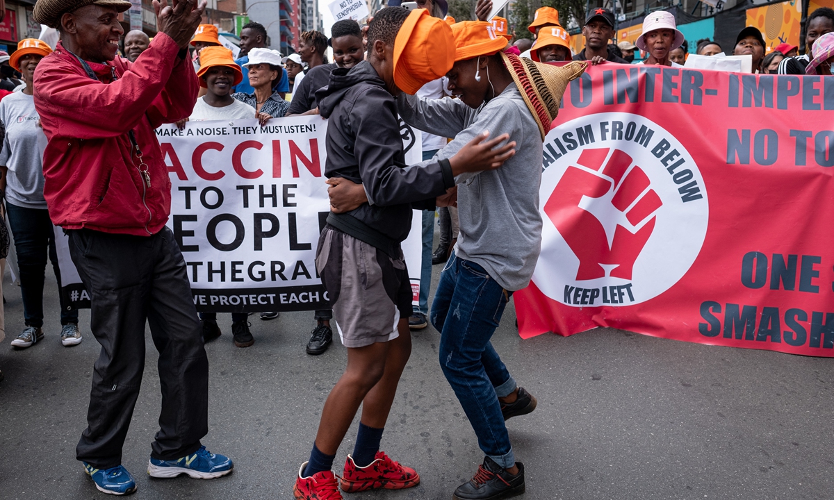 South Africans and foreign migrants hold up banners and chant slogans during a demonstration against xenophobia in Johannesburg, on March 26, 2022. Photo: AFP