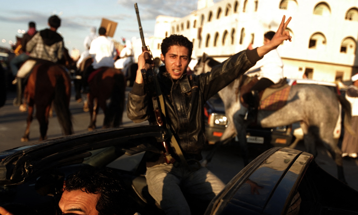 Λίβυοι διαδηλωτές συγκεντρώνονται στη Βεγγάζη στις 11 Μαρτίου 2011 καθώς η Αραβική Άνοιξη εξαπλώθηκε στη χώρα.  Οι ΗΠΑ, το Ηνωμένο Βασίλειο και η Γαλλία παρενέβησαν στη Λιβύη με εκστρατεία βομβαρδισμών στις 19 Μαρτίου 2021. Φωτογραφία: AFP