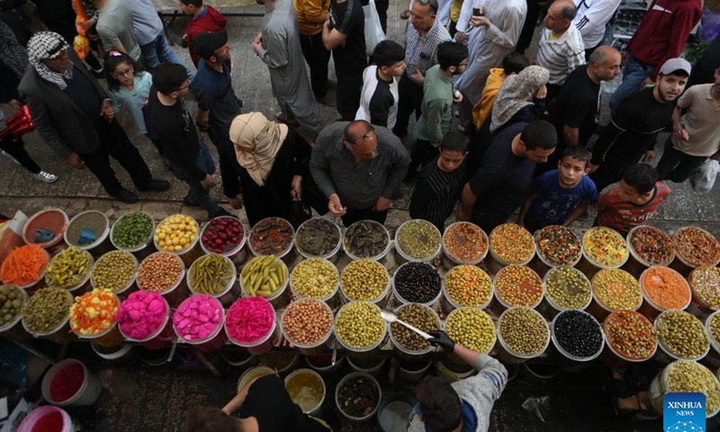 People visit a market during the Islamic holy month of Ramadan in the West Bank city of Hebron, on April 5, 2022. (Photo by Mamoun Wazwaz/Xinhua)