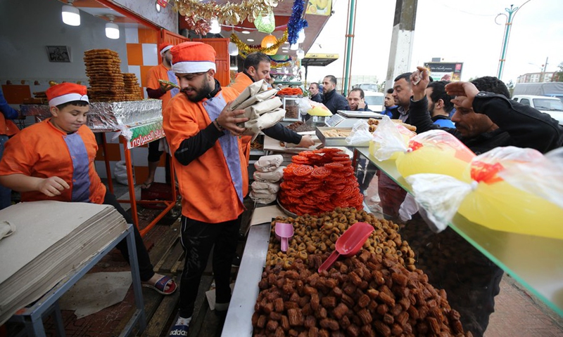 Photo taken on April 6, 2022 shows people buying traditional desserts during the holy month of Ramadan in Boufarik, Algeria.(Photo: Xinhua)