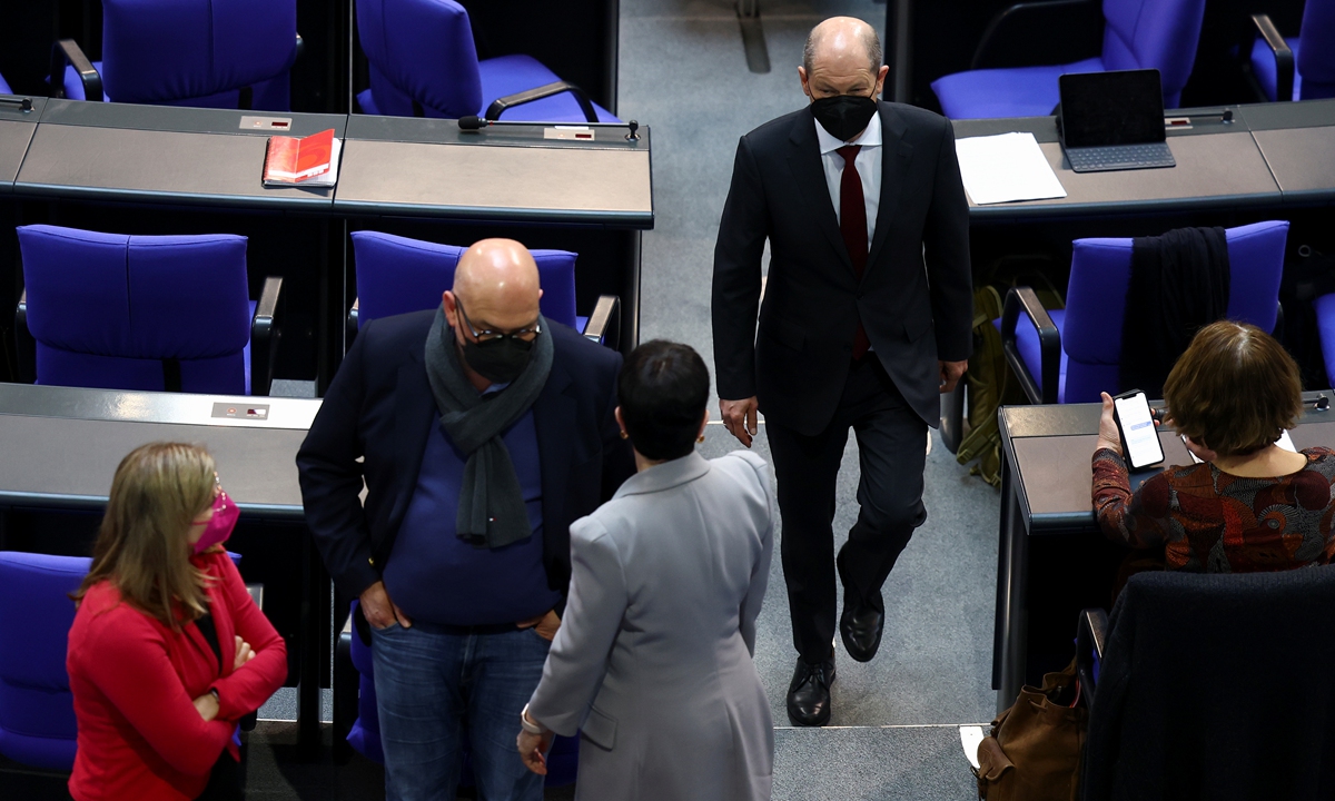 German Chancellor Olaf Scholz walks along the aisle during a session of Germany's lower house of parliament, as the Bundestag is set to vote on several proposals introducing or blocking a COVID-19 vaccine mandate for the general population, in Berlin, Germany, April 7, 2022. Photo: thepaper.cn