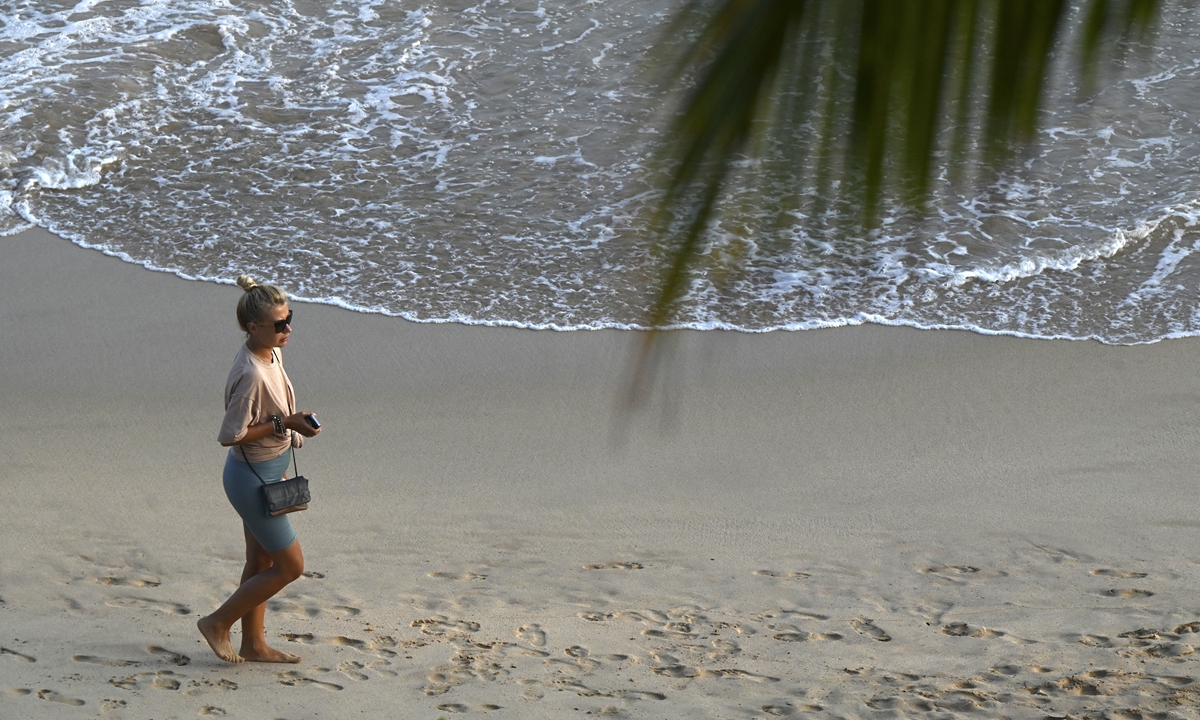 A tourist walks along a beach in Mirissa, Sri Lanka, on March 25, 2022. Photo: AFP
