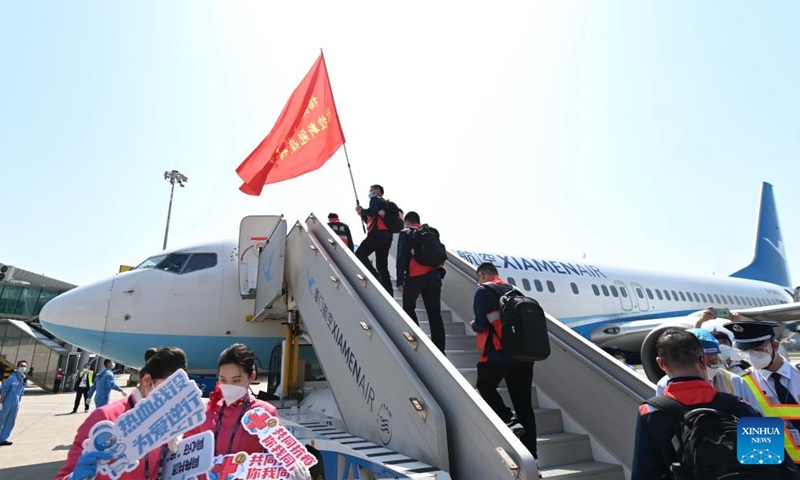 Medics board an airplane for east China's Shanghai at Changle Airport in Fuzhou, southeast China's Fujian Province, April 7, 2022. A total of 1,730 supportive medics from Fujian Province set off on Thursday from Fuzhou and Xiamen to Shanghai to aid in the battle against the resurging COVID-19 epidemic.Photo:Xinhua