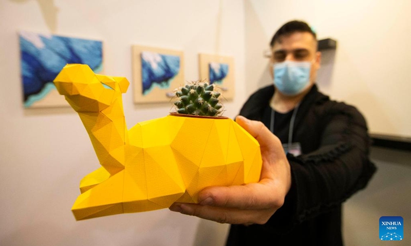 An exhibitor shows a paper artwork during the 2022 Interior Design Show in Toronto, Canada, on April 7, 2022. As Canada's premier showcase of new interior design concepts and products, the annual event is held here from Thursday to Sunday.(Photo: Xinhua)