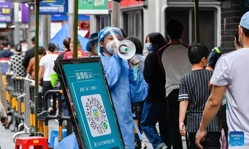 A volunteer in protective gear guides citizens at a nucleic acid testing site in Luohu District of Shenzhen, south China's Guangdong Province, March 13, 2022.Photo:Xinhua