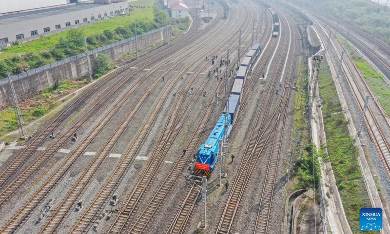 Aerial photo shows the first outbound international rail-sea freight train from China's Yangtze River to Indo-China Peninsula leaving Guoyuan Port in southwest China's Chongqing Municipality for Myanmar's Yangon, April 7, 2022. The new route from the inland port along the Yangtze River to Yangon also links Chongqing with the Indian Ocean. It comes under the framework of the New International Land-Sea Trade Corridor, a trade and logistics passage jointly built by western Chinese provinces and Singapore.(Photo: Xinhua)