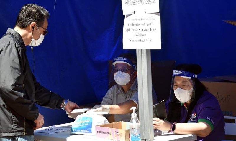 A citizen receives an anti-epidemic kit in Hong Kong, south China, April 9, 2022. On Saturday, Hong Kong registered a total of 2,535 new COVID-19 infections, including 897 by nucleic acid tests and 1,638 additional cases through self-reported rapid antigen tests, official data showed.Photo:Xinhua