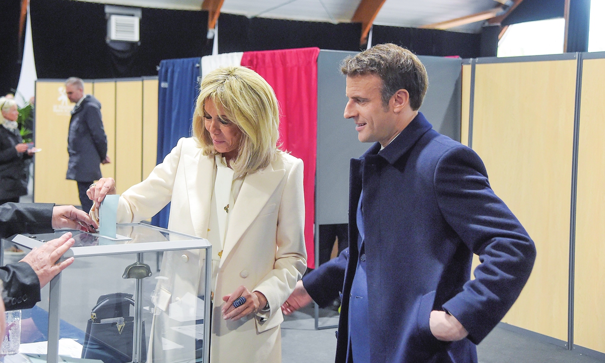 Le président français Emmanuel Macron et son épouse Brigitte Trogneux se présentent dans un bureau de vote le 10 avril 2022, jour du premier tour de scrutin de l'élection présidentielle française.Photo : VCG