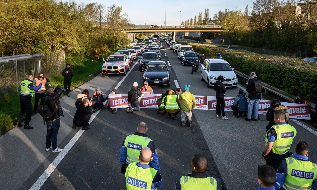 Environmental activist members of Renovate Switzerland block a motorway near Lausanne, western Switzerland on April 11, 2022. The activist group states that it will continue its actions as long as the Federal Council has not heard its request of the establishment of a national plan to renovate million houses that require emergency insulation by 2040. Photo: AFP