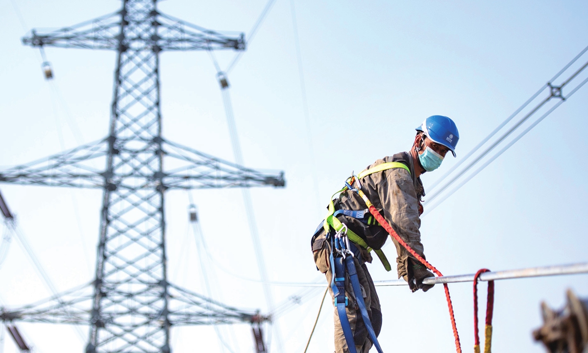 A worker from a power company in Hefei, East China's Anhui Province works at a transmission line on April 11, 2022. The line is expected to see peak use during the summer after it is finished in June. China's power consumption in February surged 16.9 percent from a year earlier to 623.5 billion kilowatt-hours. Photo: cnsphoto
