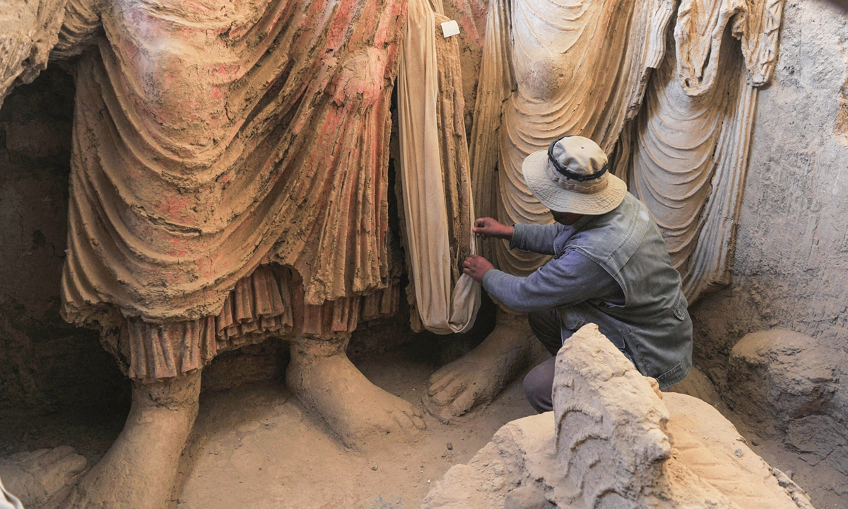 An Afghan archaeologist looks at the remains of Buddha statues discovered inside an ancient monastery in Mes Aynak, in the eastern province of Logar of Afghanistan on November 23, 2010. Photo: AFP