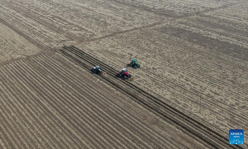 Aerial photo taken on April 9, 2022 shows farmers working on agricultural machinery at a field in Cainiu Town of Tieling County in northeast China's Liaoning Province.Photo:Xinhua